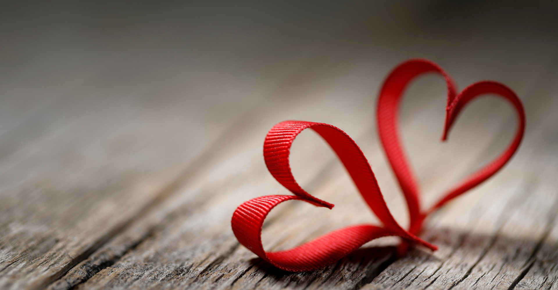Dad pushing Daughter in Cardboard Box on Hardwood Floors